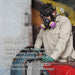 Person wearing a NIOSH-approved North 760008AW respiratory mask and protective gear, working in a hazardous environment.