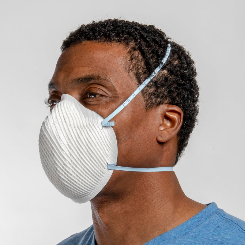 Person wearing a white Moldex 2200N95 Disposable Particulate Respiratorsagainst a gray background